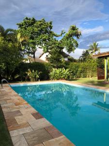 uma piscina com água azul num resort em Hostel 4 Elementos - 200 metros da Praia de Pernambuco e do Mar Casado no Guarujá