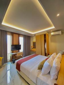 a hotel room with a large bed and a desk at The Kayangan Sanur in Sanur +62 photos