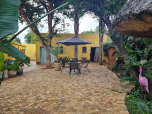 a patio with a table and an umbrella at 3 Brothers B&B in Edenvale