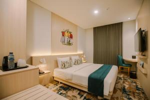 a hotel room with a bed and a television at Cordia Hotel Yogyakarta - Hotel Dalam Bandara in Glagah