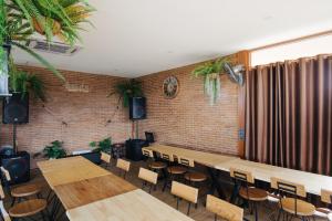 um restaurante com mesas e cadeiras de madeira e uma parede de tijolos em Srida Resort Lanna and Cafe em Chiang Mai