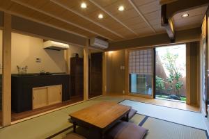 a living room with a wooden table and a window at Rikyu-an Machiya House in Kyoto