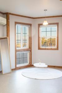 a white room with a table and two windows at Santa Beach Pension in Gangneung
