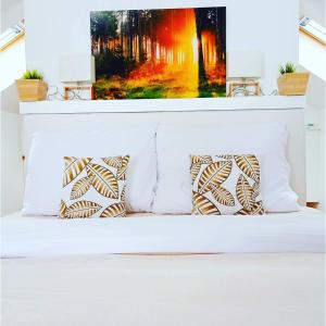 1 cama blanca con almohadas en una habitación en Brunetti Apartmány Jeseníky, en Karlovice