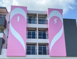 a pink apartment building with a large sign on it at 15電梯民宿 in Taitung City