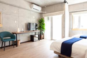 een slaapkamer met een bed, een bureau en een televisie bij Kokusai Street Garden Hotel -SEVEN Hotels and Resorts- in Naha