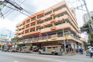 um grande edifício com camiões de comida estacionados em frente em Dechmark Hotel em Manila