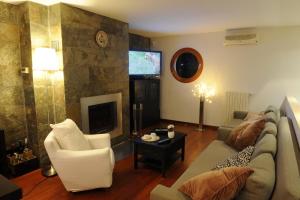 B&B Il Cielo Sui Sassi في ماتيرا: غرفة معيشة مع أريكة وتلفزيون