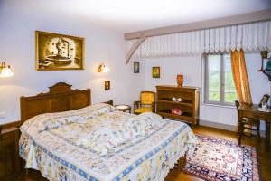1 dormitorio con cama, escritorio y ventana en La Closerie de Fronsac, en Saint-Michel-de-Fronsac