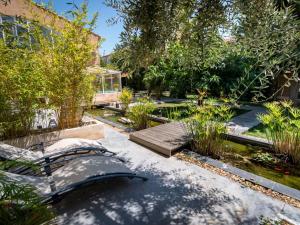 a garden with a bench and trees and a building at Chambre d'Hôtes Villa Ambrosia in Narbonne