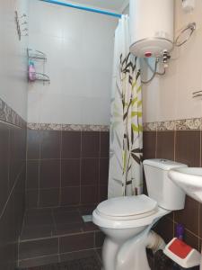 y baño con aseo, ducha y lavamanos. en Dungan House en Karakol