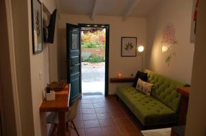 un salon avec un canapé vert et une porte dans l'établissement Domenica Apts II, à Laganas