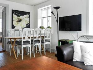スケーエンにある4 person holiday home in Skagenのリビングルーム(ダイニングルームテーブル、白い椅子付)