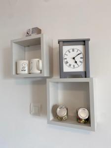 un reloj sentado en un estante con dos relojes en Apartment Lilly, en Rijeka