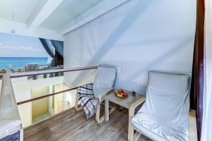 un balcón con 2 sillas, una mesa y el océano en Stony Island Hotel, en San Petersburgo