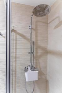 La salle de bains est pourvue d'une douche et de toilettes blanches. dans l'établissement LOFT CABANELAS, à Cangas