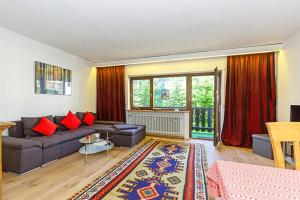 sala de estar con sofá y almohadas rojas en Ferienwohnung Kothen, en Reit im Winkl