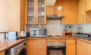 a kitchen with wooden cabinets and a stove top oven at CONCORD APARTMENTS Unit 1 in Stellenbosch