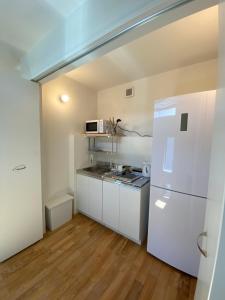 eine Küche mit weißen Schränken und einem weißen Kühlschrank in der Unterkunft B&B KAMAKURA in Kamakura