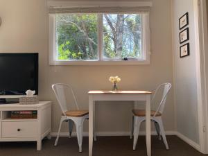 a room with a table and two chairs and a window at Aroha Studio in Katoomba