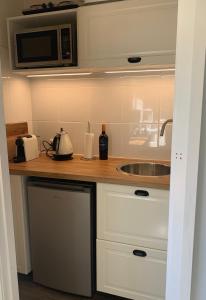 a kitchen counter with a sink and a microwave at Aroha Studio in Katoomba