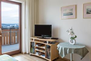 a living room with a television and a balcony at Ferienwohnung Gebhart in Öhningen