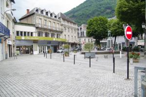 a cobblestone street with street signs in a town at Maison hyper-centre Bagnères de Luchon in Luchon
