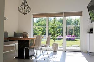 een woonkamer met een tafel en stoelen en een raam bij Nordic Park in Græsted