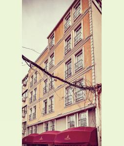 un edificio alto con finestre e tenda rossa di Galata Hill Hotel a Istanbul