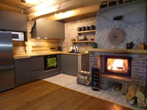 a kitchen with a fireplace in the middle of it at Saullēkti ozolos pie Ežezera in Ezernieki