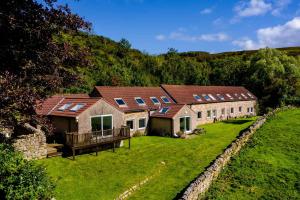 an image of a house with solar panels on it at Long Byres Holiday Cottages in Brampton