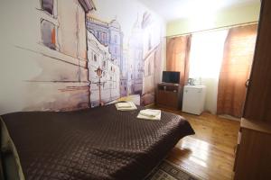ゲレンジークにあるGuest House on Starshinova st. 14のベッドルーム1室(ベッド1台付)が備わります。壁には絵画が飾られています。