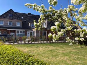 dom z kwitnącym drzewem w ogrodzie w obiekcie Waastwinj - 500m vom Strand w mieście Utersum
