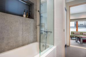 a bathroom with a shower and a bath tub at Kitanishi 3 by H2 Life in Kutchan +16 photos