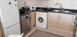 a kitchen with a washing machine and a sink at 10 Seahorse, Scottburgh in Scottburgh