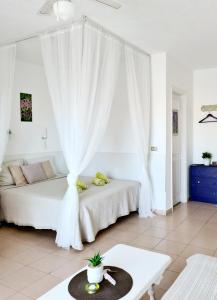 プエルト・デ・サンティアゴにあるStudia Puerto de Santiagoの白いベッドルーム(ベッド1台、テーブル付)
