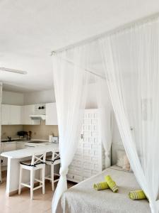 1 dormitorio blanco con 1 cama y cocina en Studia Puerto de Santiago, en Puerto de Santiago