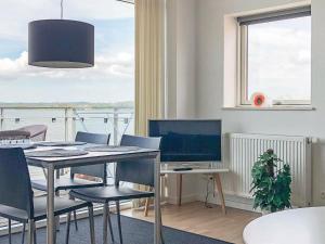 a dining room with a table with chairs and a television at Holiday Home Banedæmningen II in Hejls