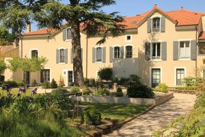 a large house with a garden in front of it at La Villa des Charmilles in Vernoux-en-Vivarais