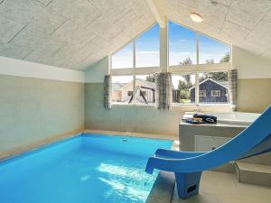 a indoor swimming pool with a slide in a house at 16 person holiday home in Hasselberg in Kappeln