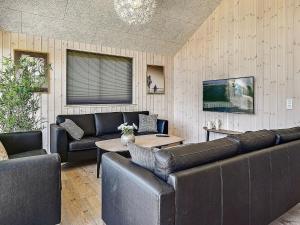 a living room with leather furniture and a tv at 16 person holiday home in Hasselberg in Kappeln