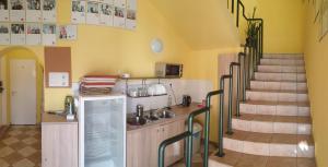 uma cozinha com uma escada num quarto com paredes amarelas em Jáde Panzió em Budapeste