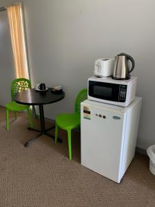 a small table and a microwave on top of a refrigerator at HOPETOUN COMMUNITY HOTEL MOTEL in Hopetoun