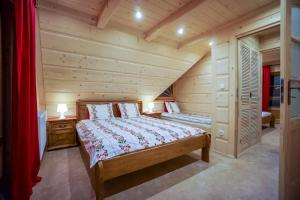a bedroom with a bed in a log cabin at Domek Góralski Symek in Poronin