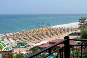 uma praia com cadeiras e guarda-sóis e o oceano em Sea View Rental Front Beach em Golden Sands