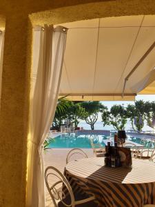 een tafel met een witte parasol en een zwembad bij Hotel San Marco in Bardolino