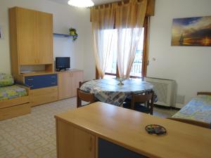 a living room with a table and a room with a kitchen at Argea in Grado