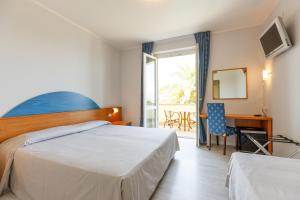 a hotel room with a bed and a desk and a window at Hotel San Marco in Bardolino