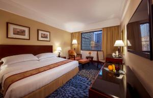 a hotel room with a bed and a large window at Hotel Presidente Macau in Macau