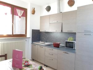 a kitchen with a sink and a microwave at Casa Vacanze Orchidea in Pinerolo